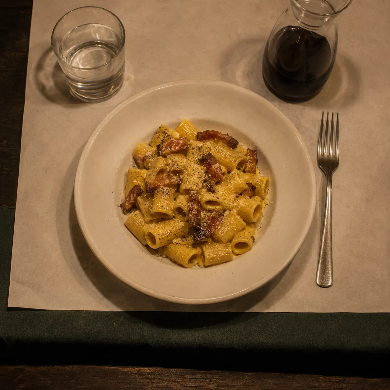Rigatoni alla carbonara con guanciale croccante, serviti al tavolo