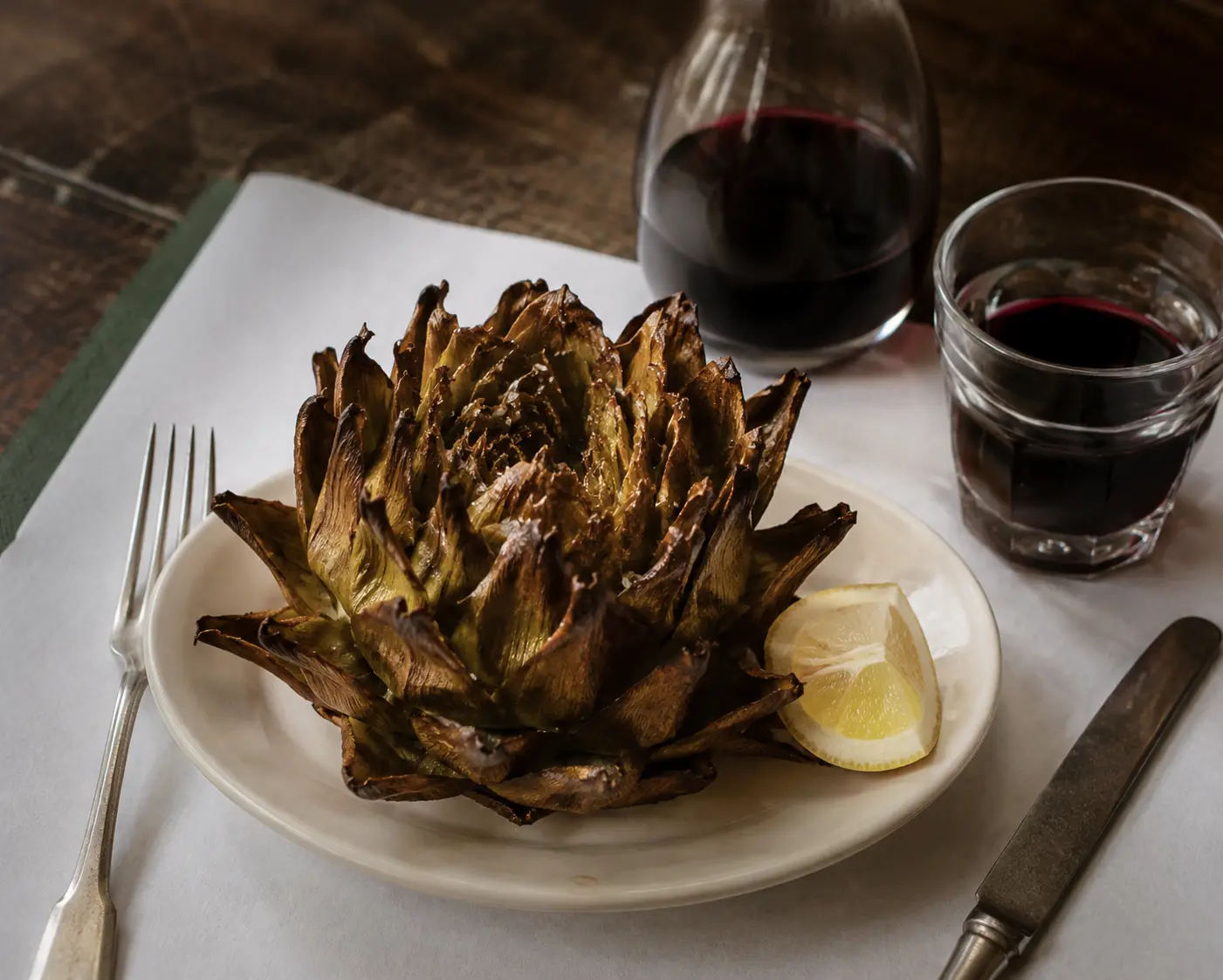 Carciofo alla giudia fritto, servito con uno spicchio di limone